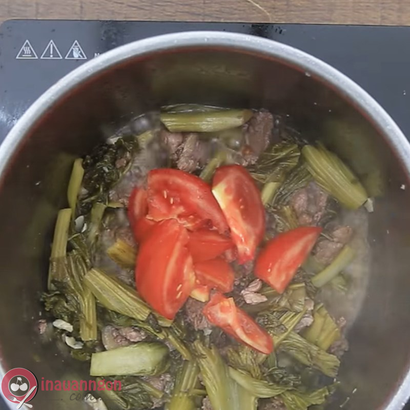 Cho lần lượt dưa cải và cà chua vào phần thịt bò đã được xào tái