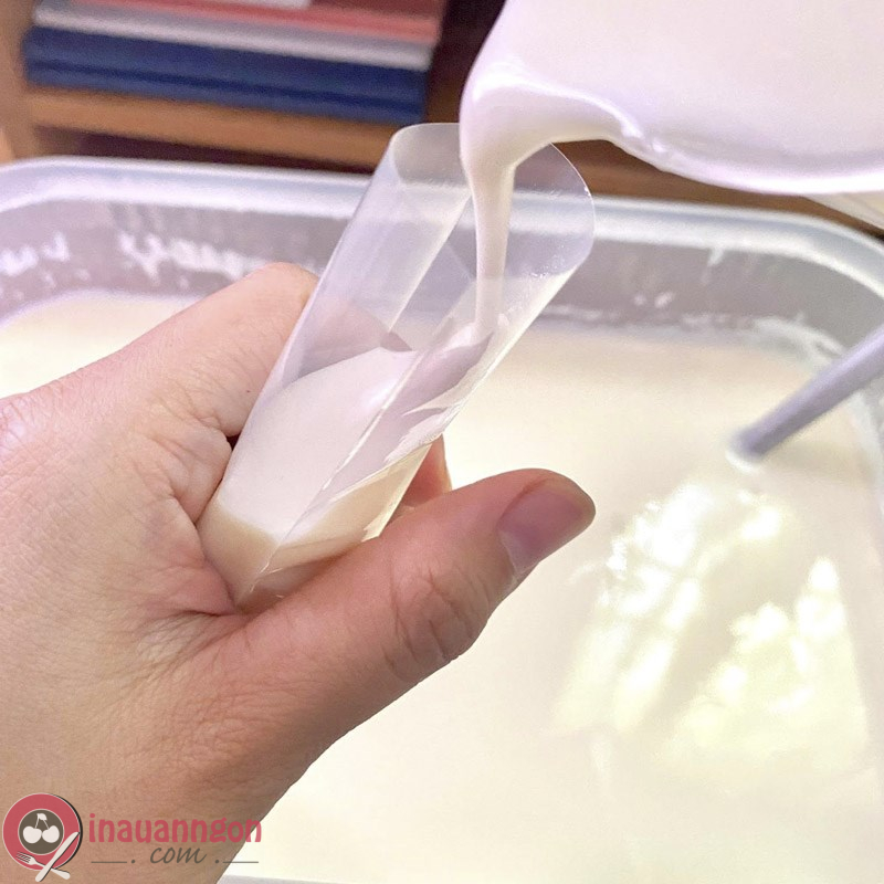 Cho sữa chua vào bịch, buộc chặt bằng dây chun 